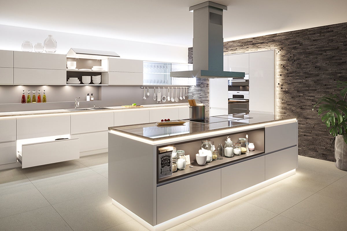 Bucătărie modernă cu insulă de gătit, hotă și dulapuri încorporate.