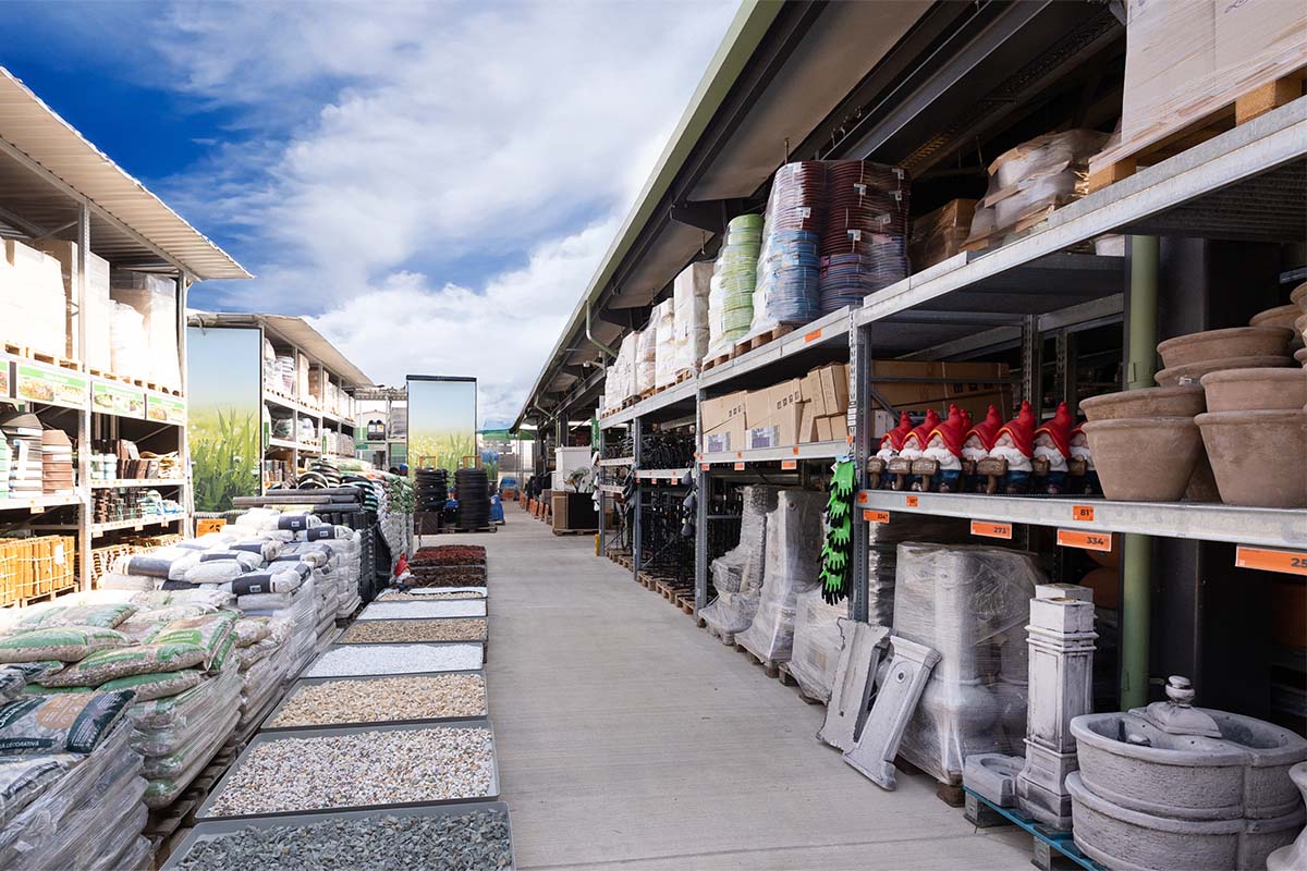 Alee într-un magazin Hornbach cu produse de grădină, cum ar fi pietre, plante de pământ și pitici de grădină.