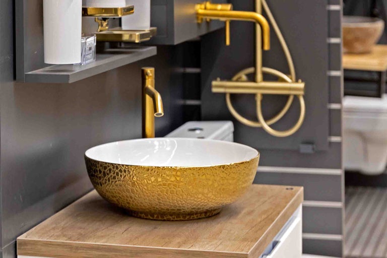 Chiuvetă cu suprafață aurie pe blat de lavoar