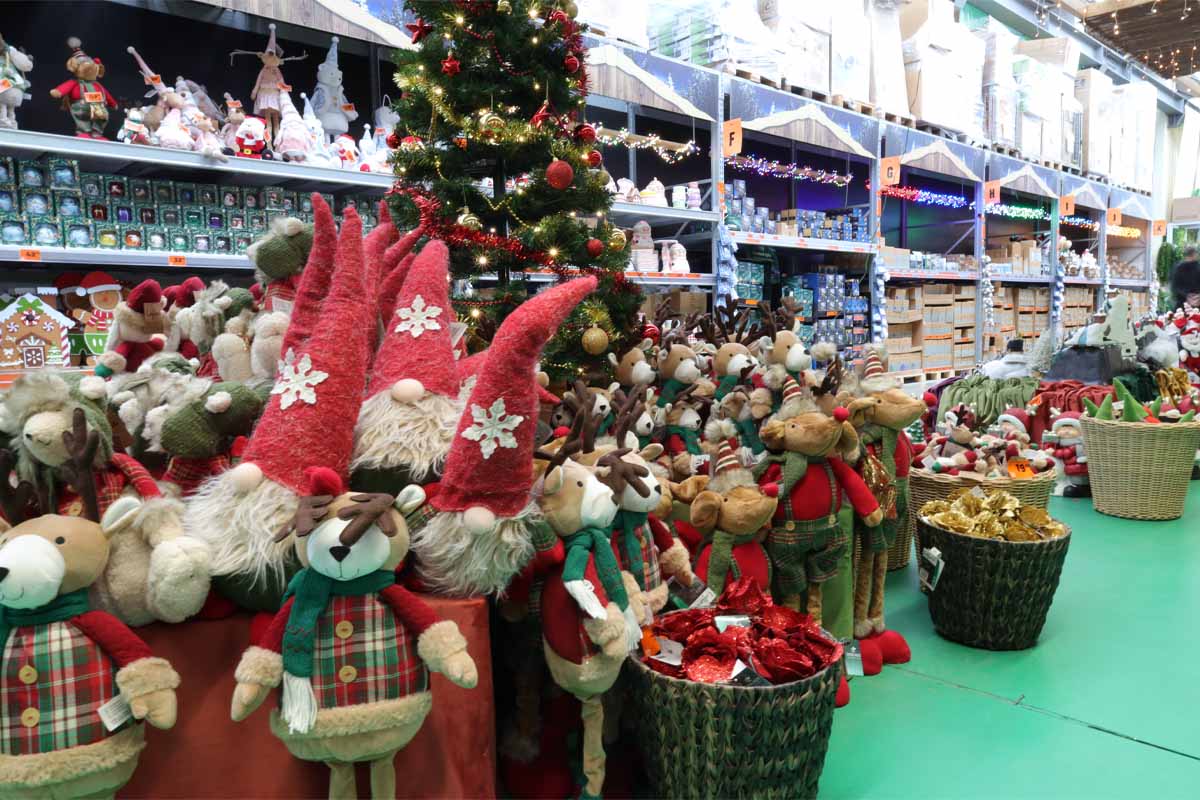 Asortiment de decorațiuni de Crăciun în magazinul Hornbach, inclusiv pitici de pluș și reni.