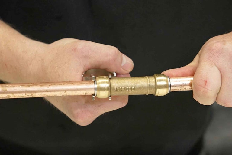 Montarea unui fiting rapid din alamă pe o țeavă de cupru.