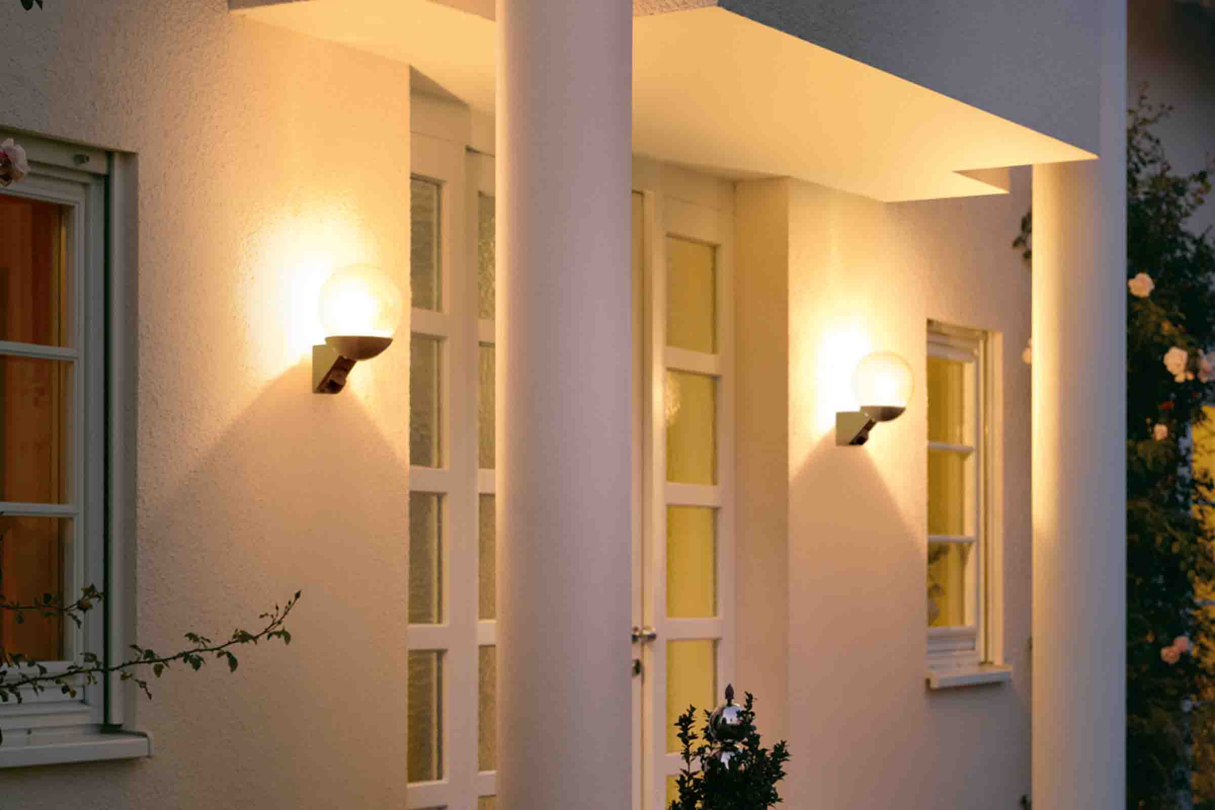 Fațadă de casă cu două aplice de perete sferice de exterior iluminate