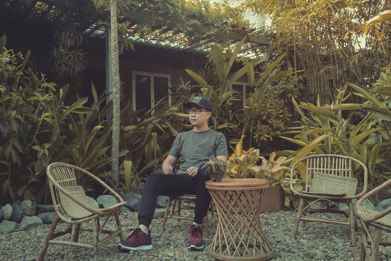 Scenă de grădină cu mobilier din bambus și o persoană