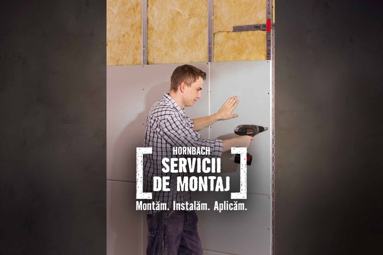 Un bărbat montează un perete cu o mașină de găurit, prezentat în contextul serviciilor de montaj Hornbach.