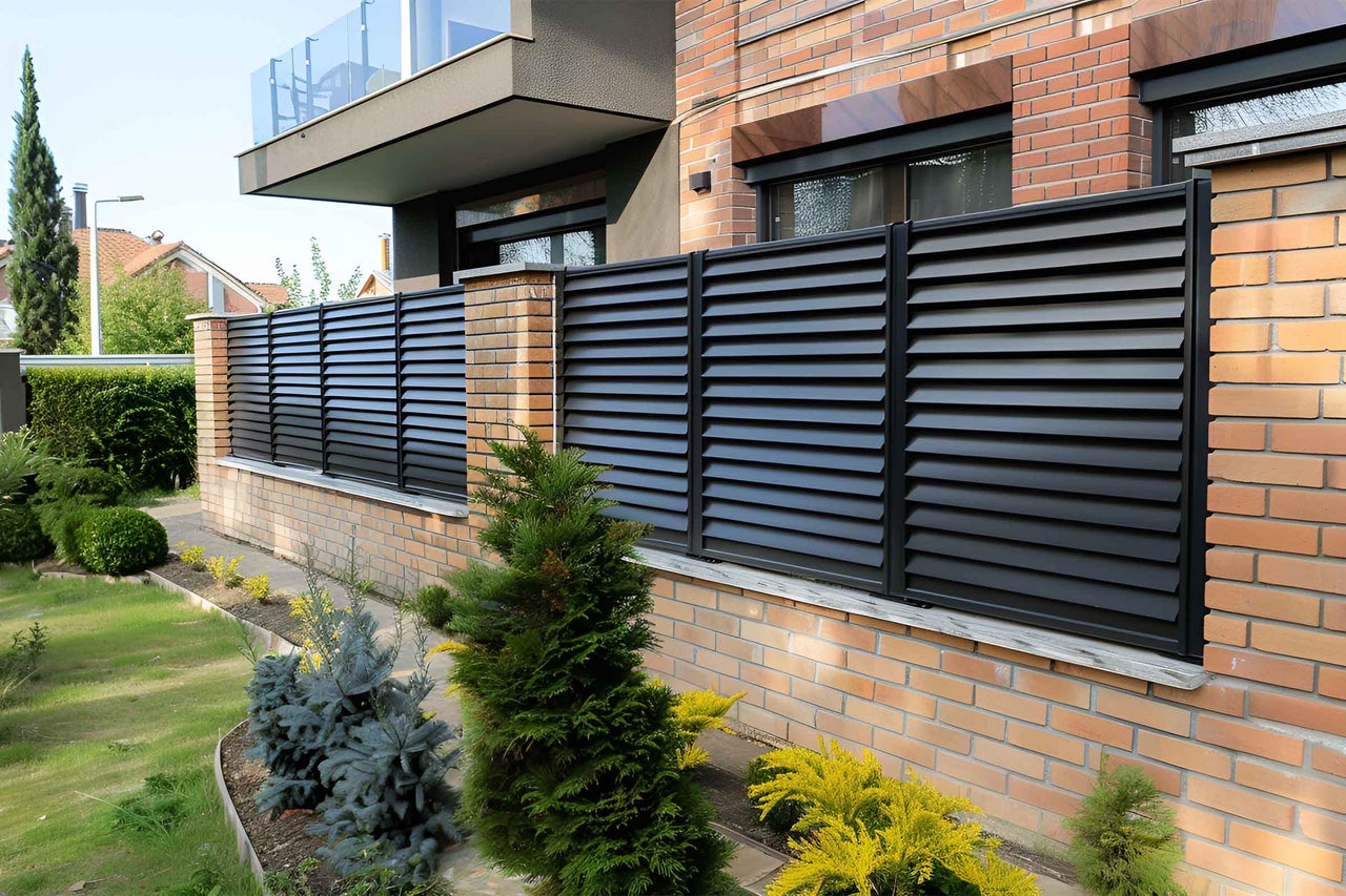 Gard de protecție vizuală cu structură lamelară în fața unei case