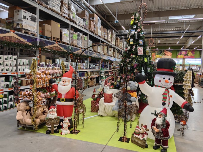 Decorațiuni de Crăciun cu Moș Crăciun, om de zăpadă, ursuleți de pluș și pomi de Crăciun într-un magazin de bricolaj