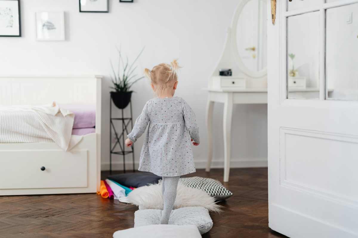 Dormitor luminos cu copil, pat și masă de toaletă albă