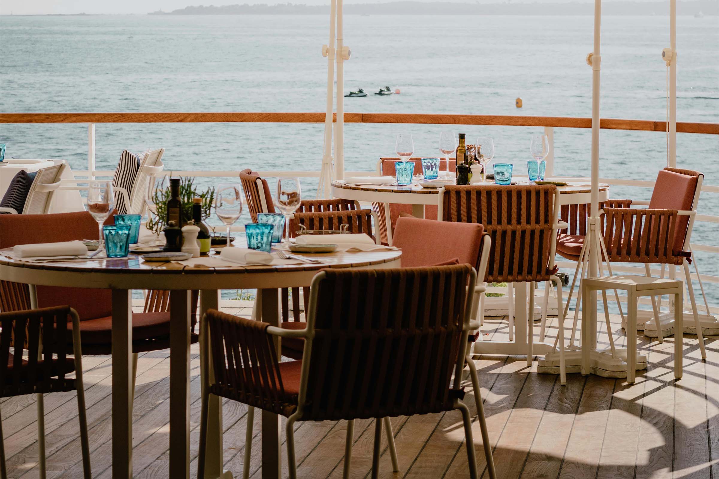 Terasa restaurantului cu mese, scaune și vedere la mare