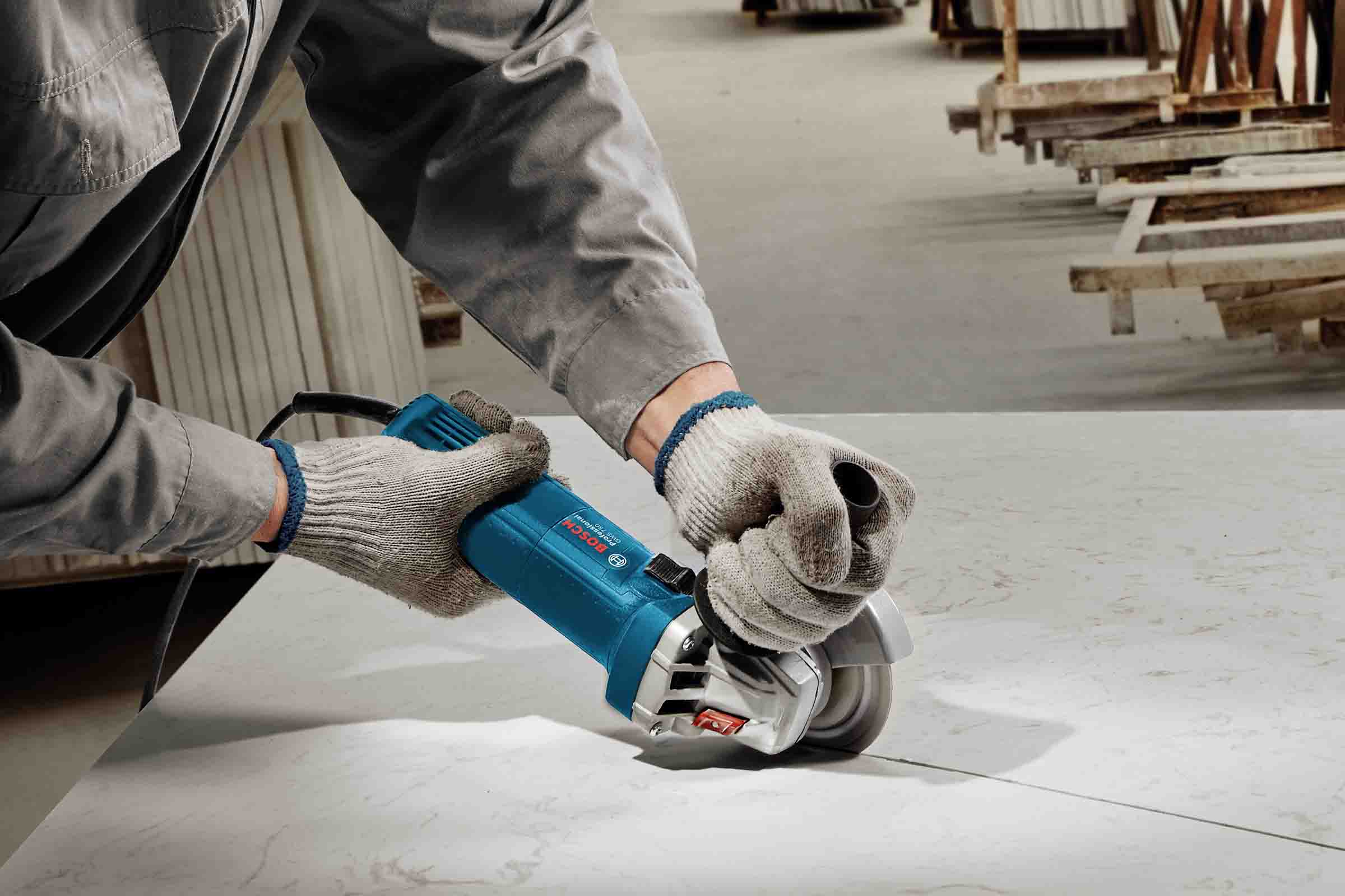 O persoană folosește un polizor unghiular marca Bosch pentru a tăia materiale.