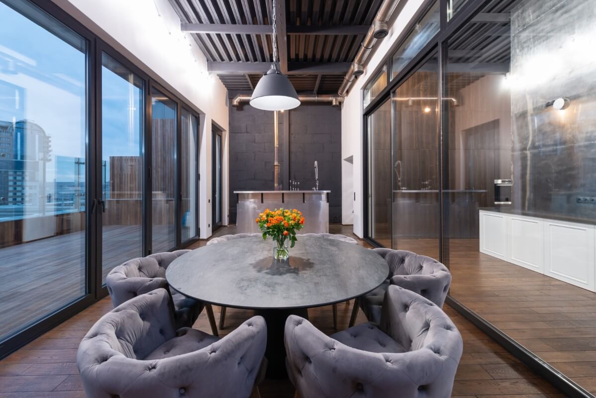 Fotografie de interior a unei zone de luat masa cu o masă rotundă, scaune și mobilier modern