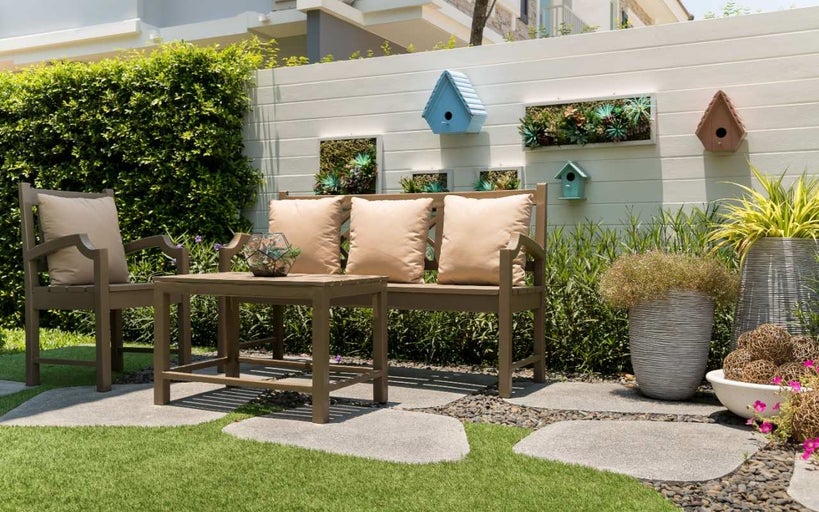 Set de mobilier de grădină cu bancă, scaun și masă pe gazon cu decorațiuni precum jardiniere și case pentru păsări
