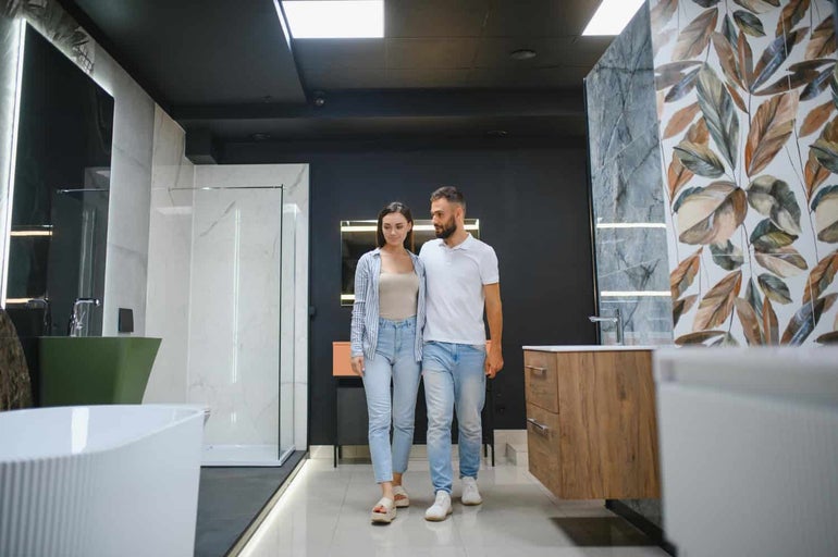 Baie luminoasă cu duș, dulap sub chiuvetă și cadă, plus un cuplu