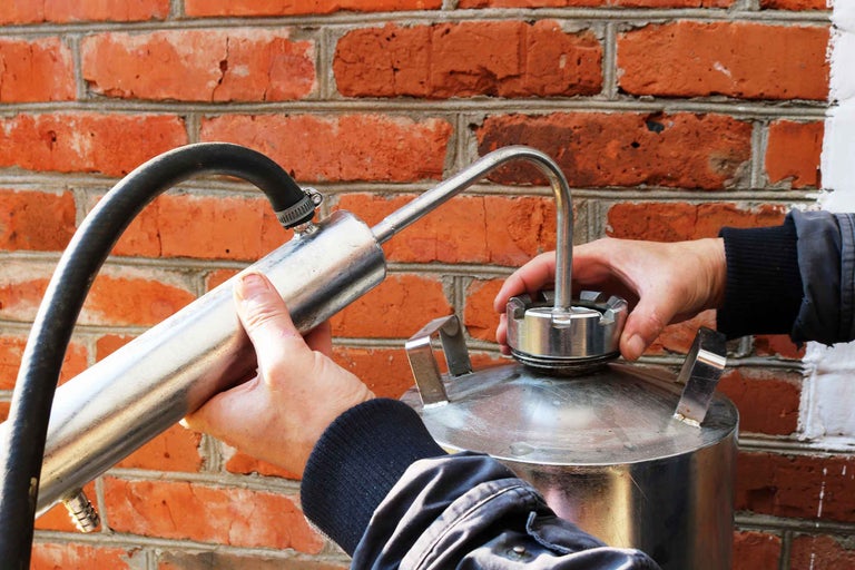 Instalarea unui aparat de distilare metalic pe un perete de cărămidă