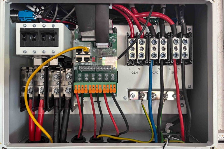 Tablou electric de distribuție deschis cu întrerupătoare automate, blocuri terminale, o placă de circuit și cablaj.