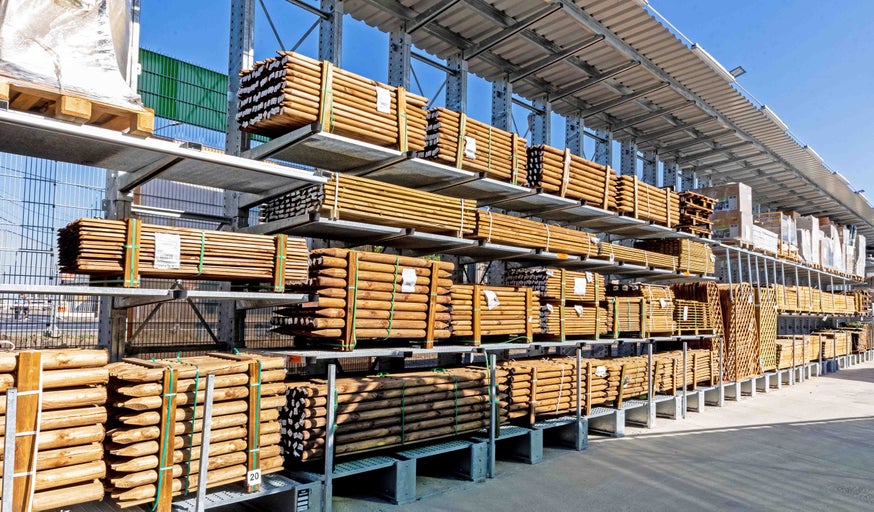 Stâlpi și șipci din lemn pe rafturile de depozitare din magazinul Hornbach