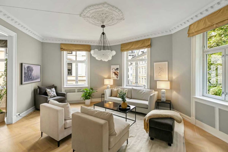 Cameră de zi cu canapea, fotoliu, măsuță de cafea și lumină naturală