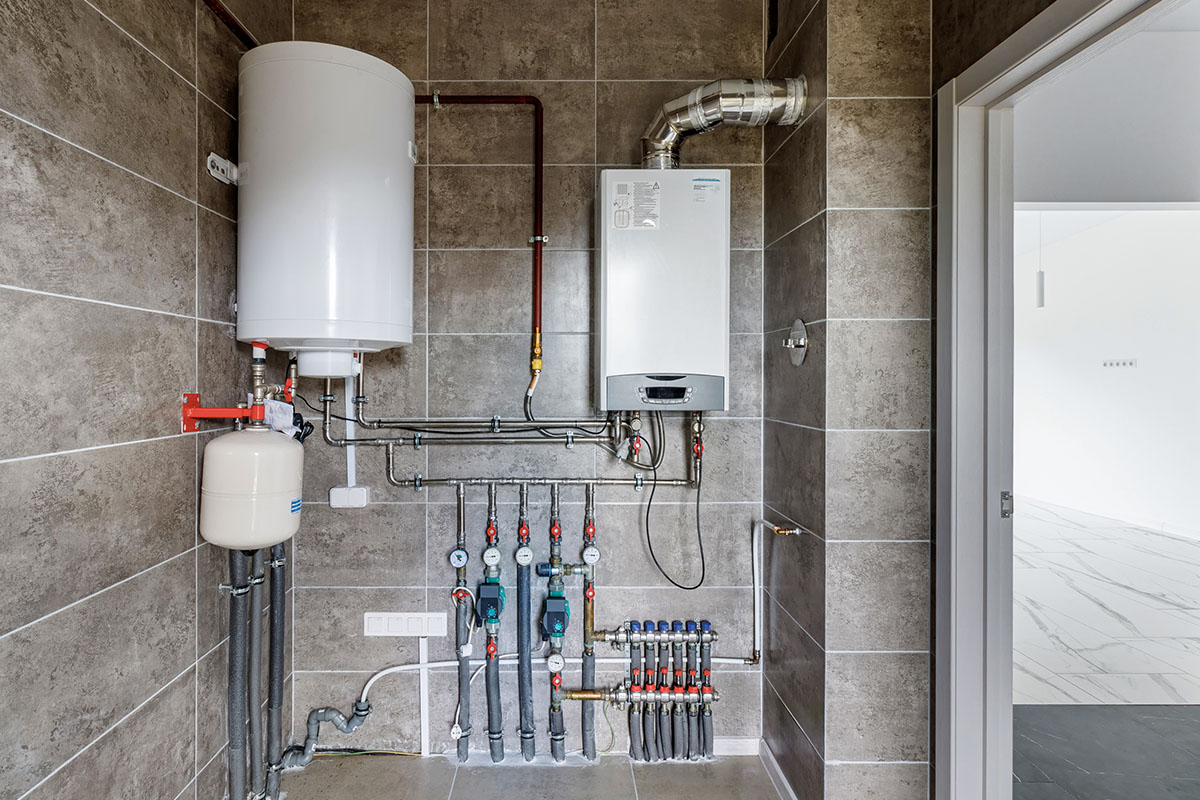 Sală de încălzire cu boiler de apă caldă, cazan și distribuitor