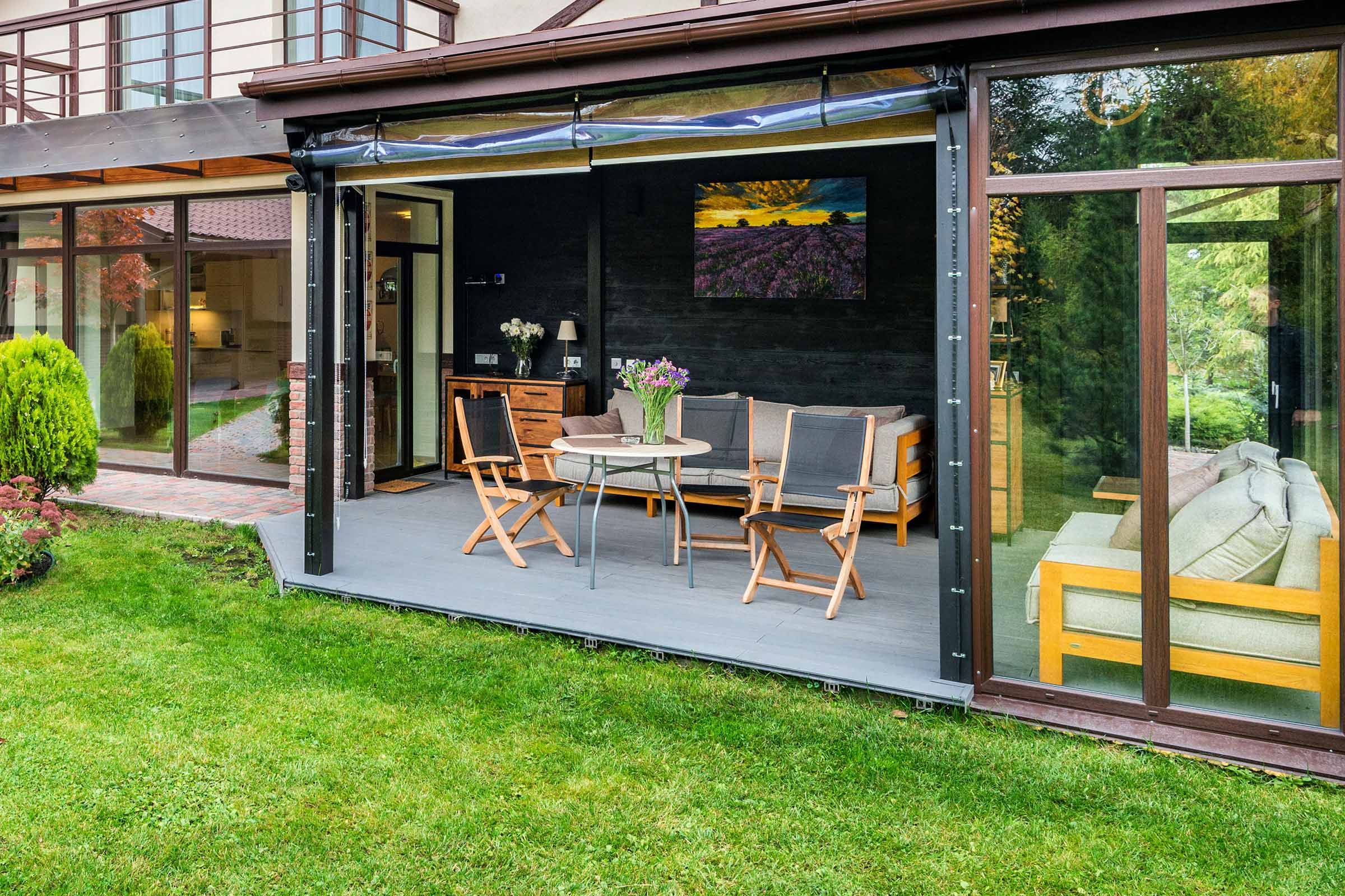 Terasa acoperită cu mobilier de grădină și vedere spre verdeață