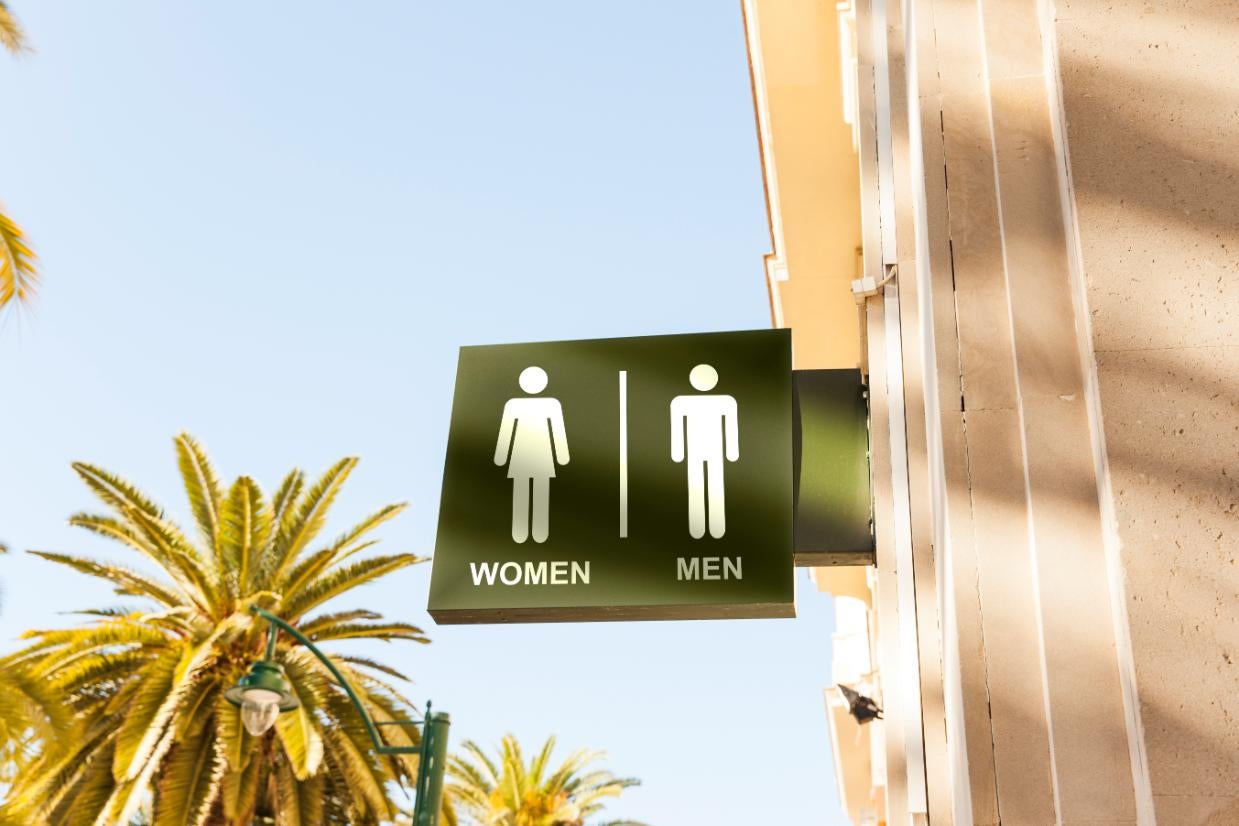Indicator toaletă pentru femei și bărbați cu pictograme și textul Women și Men.