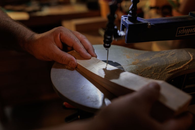 Artizan taie o bucată de lemn cu un fierăstrău de traforaj de la Scheppach