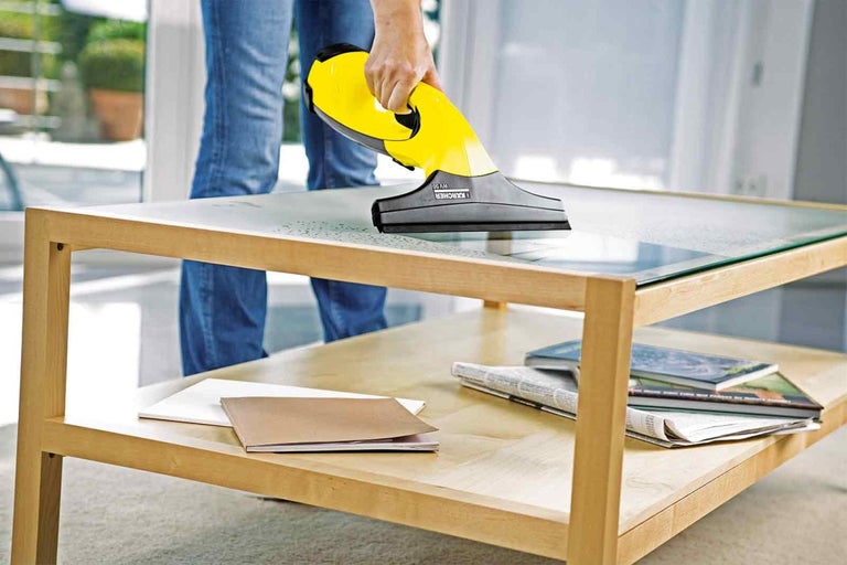Aspirator de geamuri în uz pe o masă de sticlă