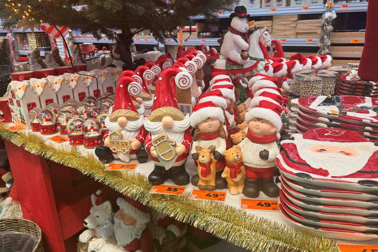 Articole de decoratiuni de Craciun in magazinul Hornbach, cu figurine spiridusi, om de zapada, farfurii si accesorii prezentate pe rafturi.
