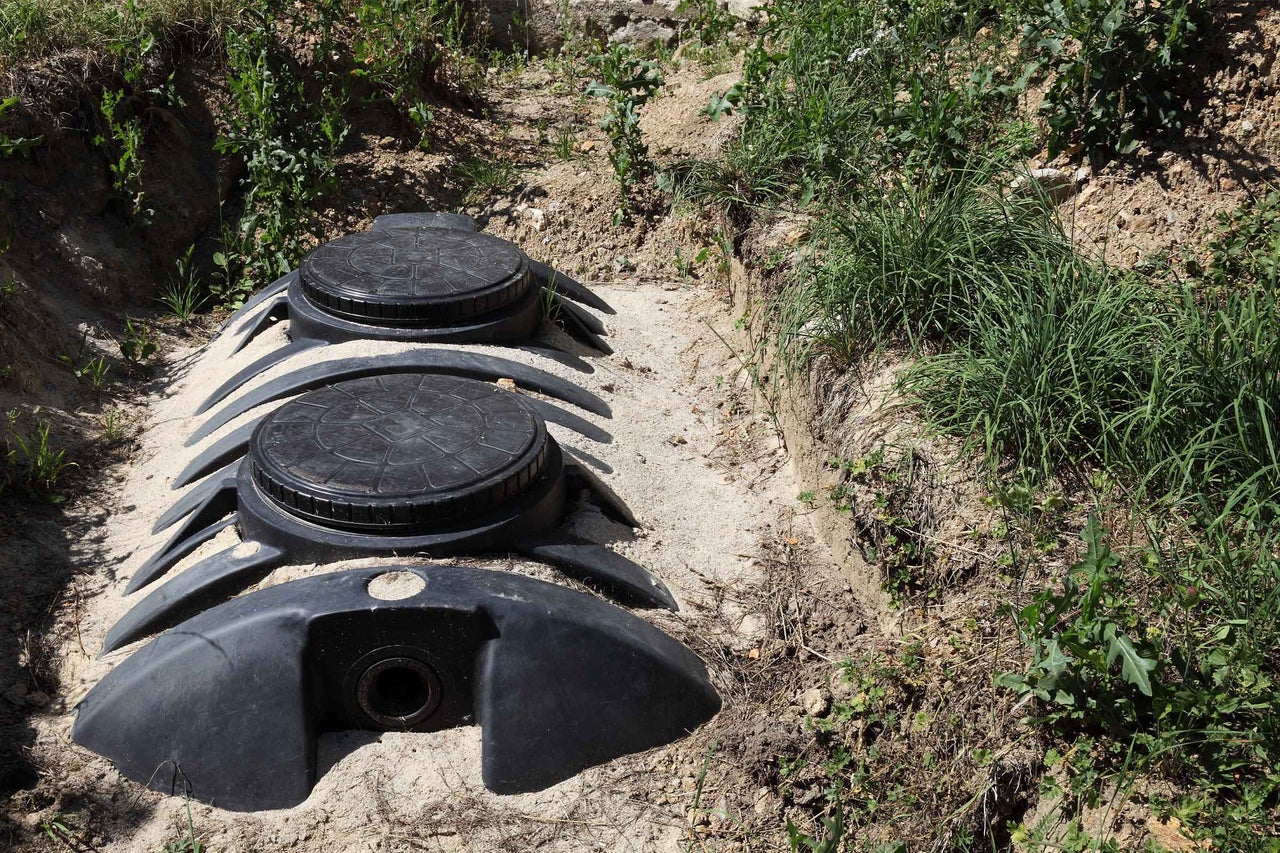 Rezervor subteran negru din plastic pentru apă de ploaie sau apă uzată instalat într-o groapă.