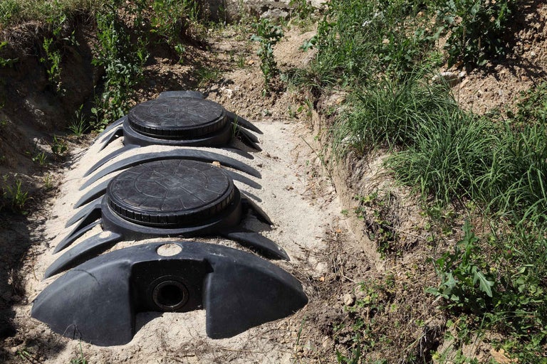 Rezervor subteran negru din plastic pentru apă de ploaie sau apă uzată instalat într-o groapă.