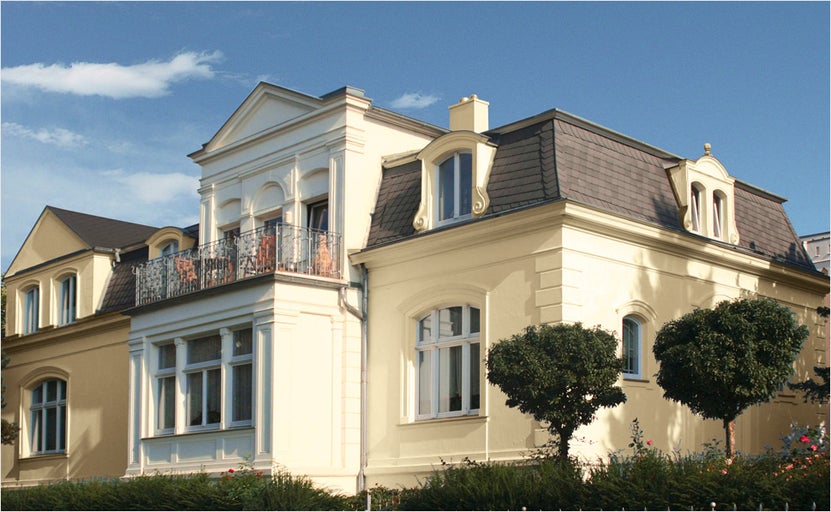 Bloc de apartamente cu fațadă tencuită, lucarne și balcon