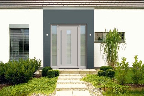 Zona de intrare a unei case cu ușă de intrare, panouri laterale și o potecă pavată prin grădină