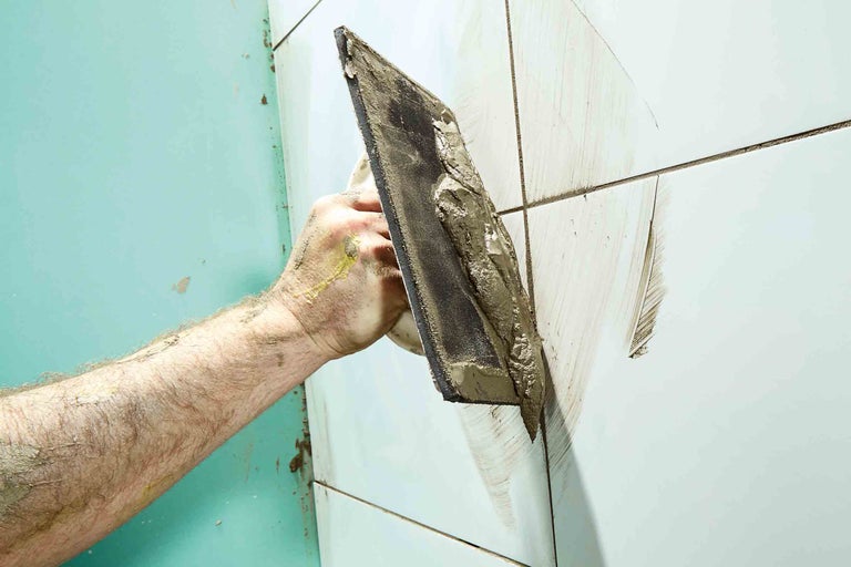 Faianțar cu șpaclu la chituirea plăcilor