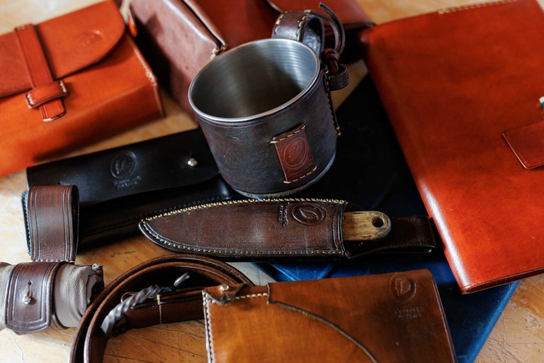 Asortiment de diverse articole din piele, inclusiv genți, agende și un cuțit cu teacă