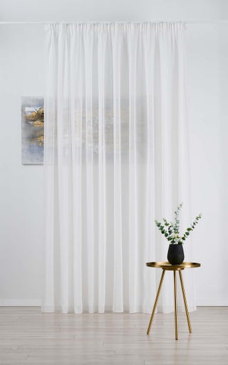 Scenă cu o perdea albă transparentă, o măsuță și un tablou pe perete