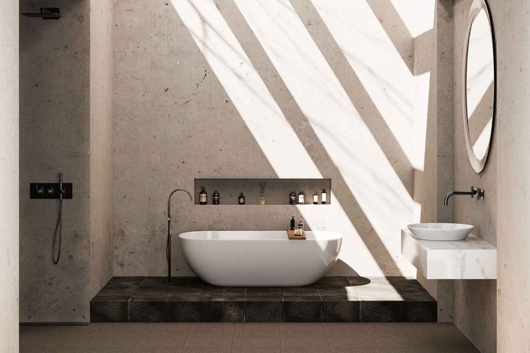 Baie modernă, luminoasă, cu cadă de sine stătătoare, baterie de pardoseală, duș de tip walk-in și lavoar pe blat, cu pereți cu aspect de beton.