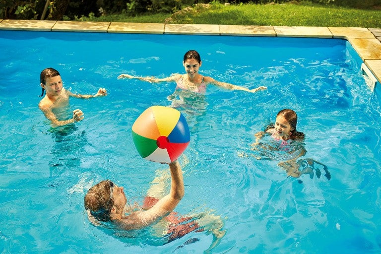 Copii se joacă cu o minge în piscină