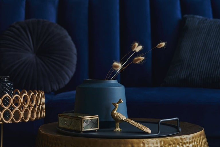 Atmosferă decorativă de locuit cu canapea, perne, vază, cutie de bijuterii și figurină decorativă