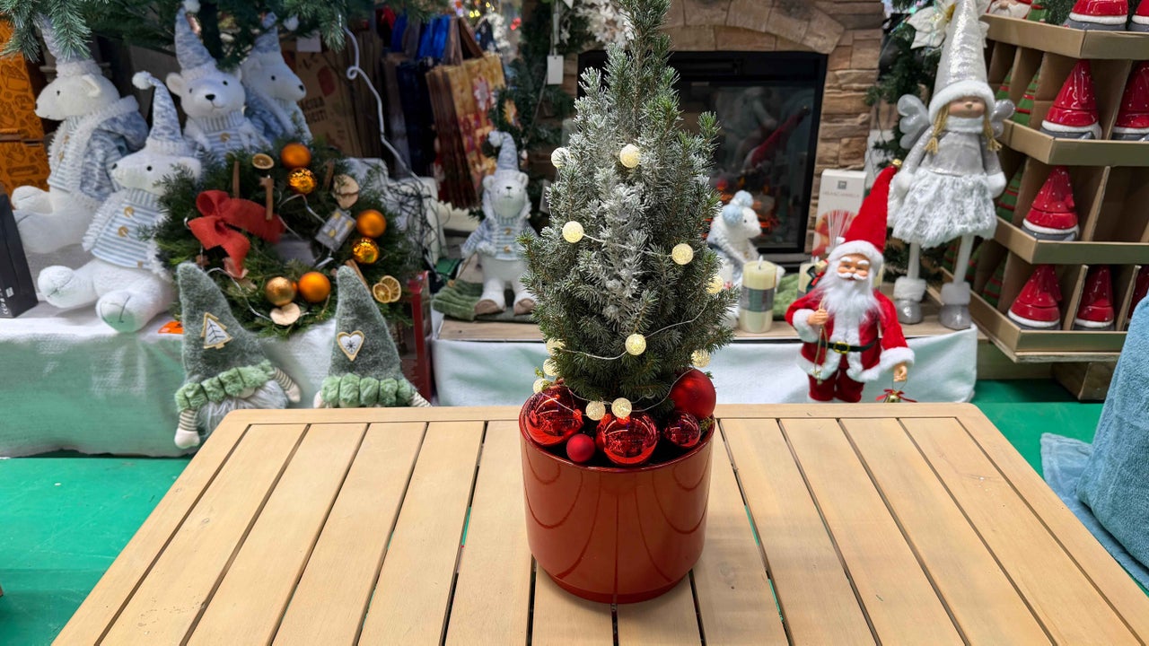 Mini brad de Crăciun decorativ cu luminițe și globuri într-un ghiveci roșu