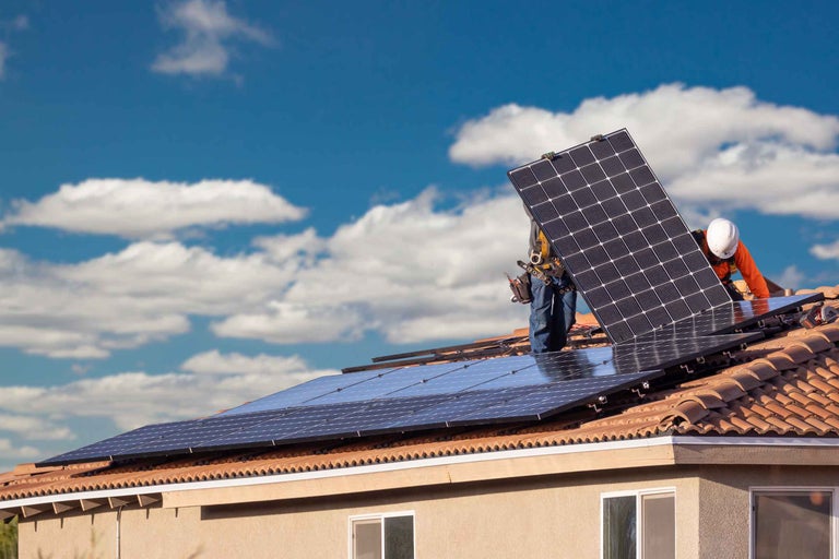 Instalarea panourilor solare pe acoperișul unei case pentru producerea de energie.