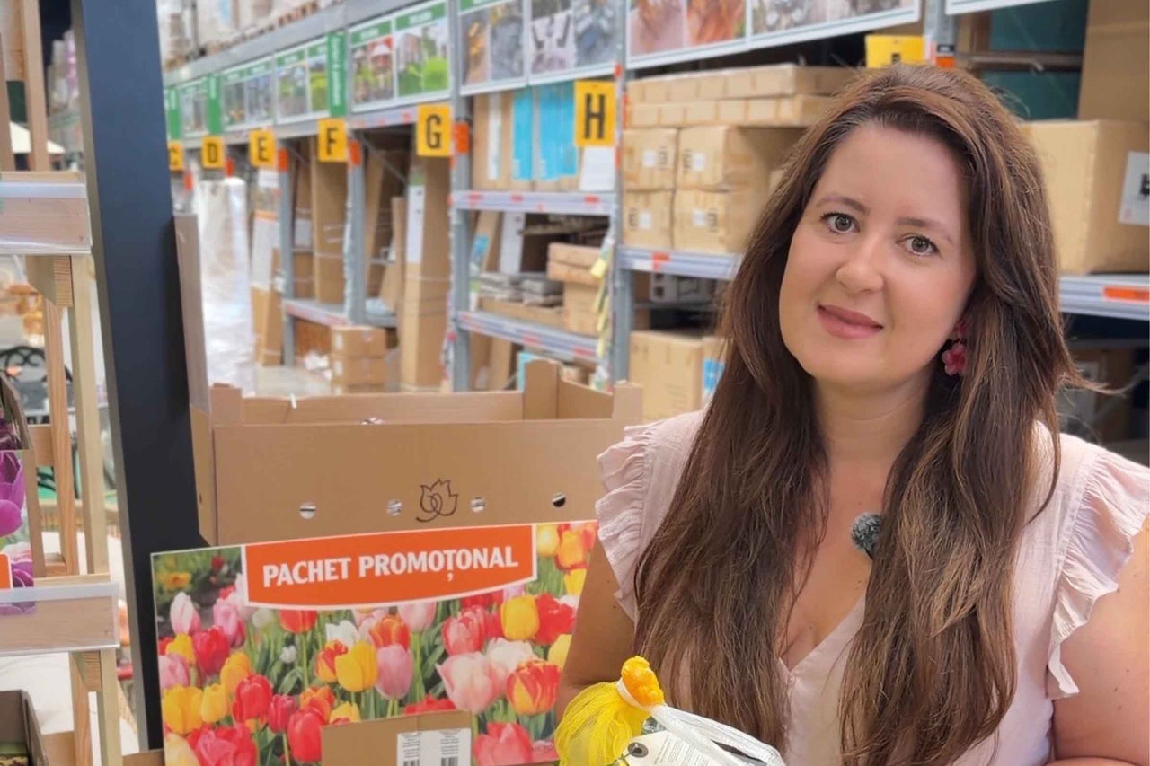 O angajată prezintă un pachet promoțional cu bulbi de flori într-un magazin Hornbach.