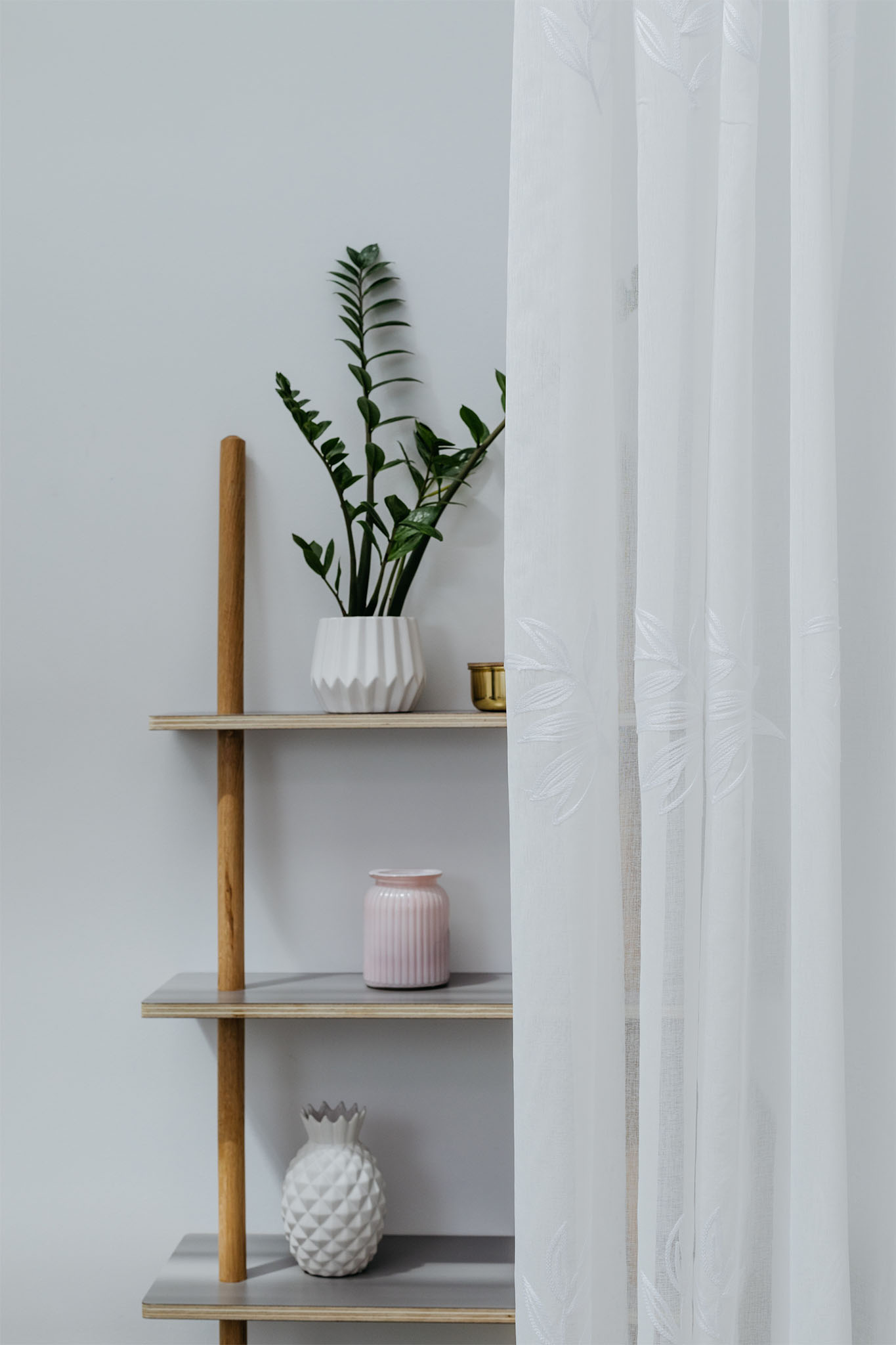 Raft decorativ cu plante, vaze și o perdea cu model floral