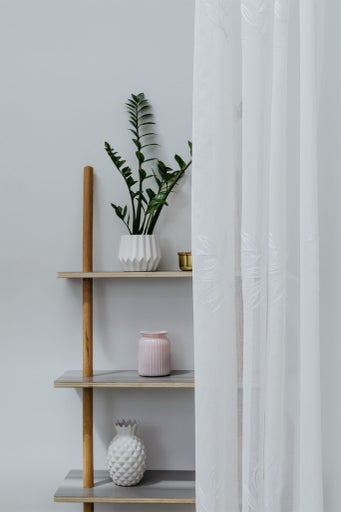 Raft decorativ cu plante, vaze și o perdea cu model floral