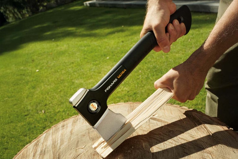 Topor Fiskars Ultra despărțind lemne pe un ciot de copac
