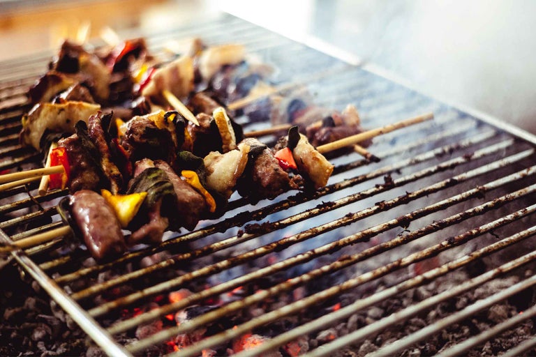 Mai multe frigărui de carne și frigărui de legume pe un grătar