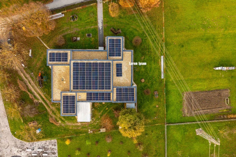 Vedere aeriană a unei clădiri cu acoperiș plat, dotată cu panouri fotovoltaice pentru producerea de energie solară.