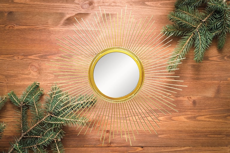 Oglindă decorativă în stil solar cu ramuri de brad pe fundal de lemn