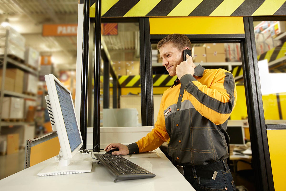Angajat la biroul de informații cu computer și telefon în magazinul Hornbach.