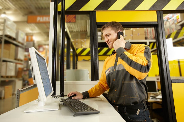 Angajat la biroul de informații cu computer și telefon în magazinul Hornbach.