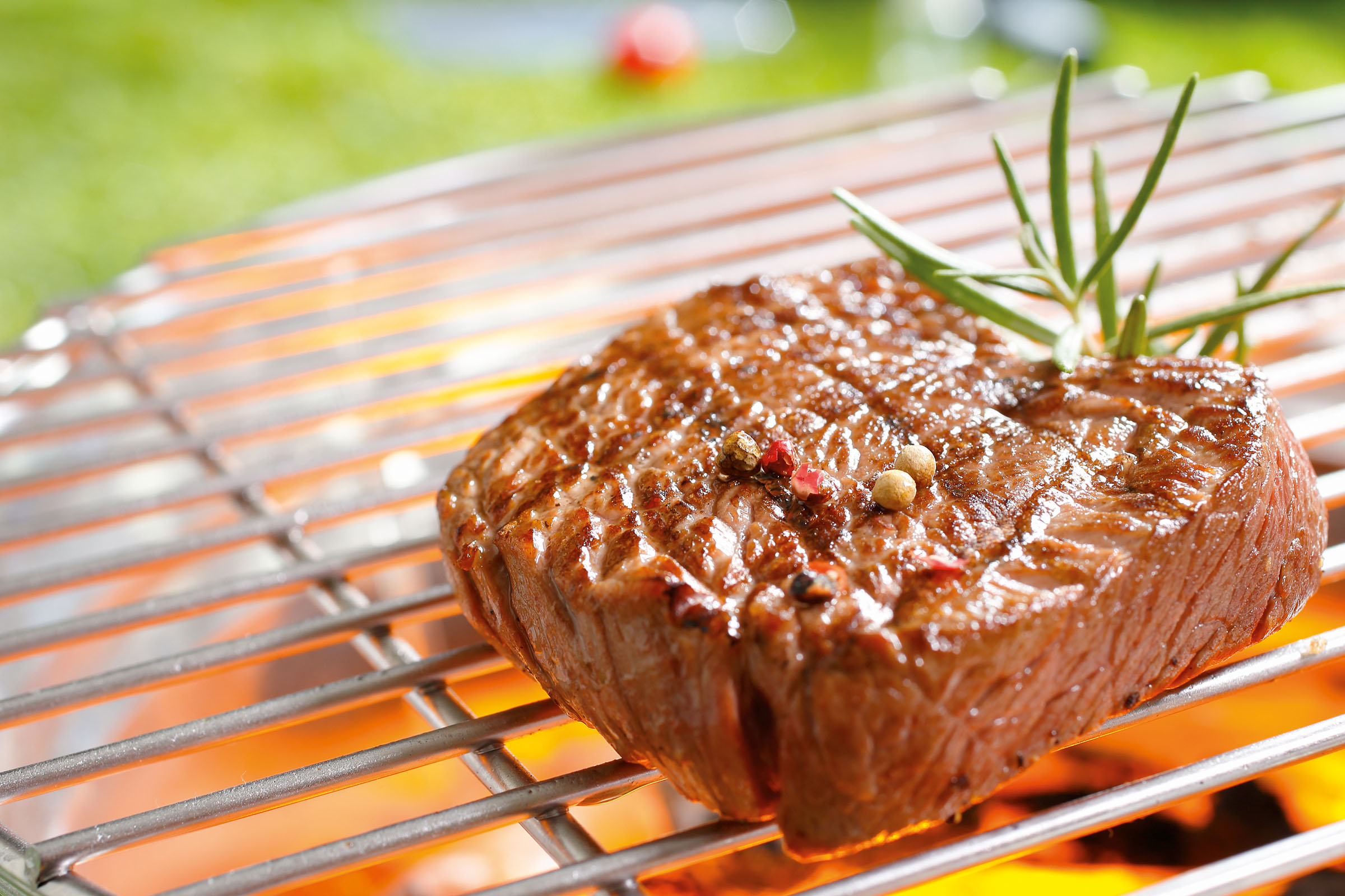 Un steak la grătar cu rozmarin pe un grătar.