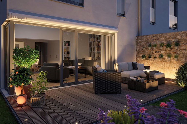 Terasa cu scânduri de terasă, mobilier de grădină și iluminat pentru o atmosferă confortabilă