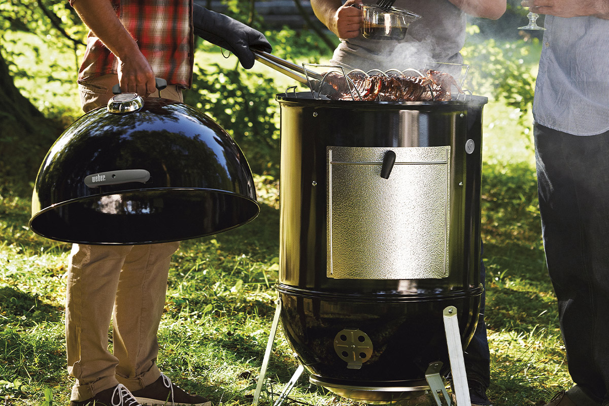 Fumătoare Weber Smokey Mountain Cooker cu persoane care fac grătar
